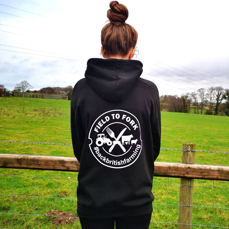 May include: Black hoodie with a white logo that says "Field to Fork #backbritishfarming" with a tractor, fork, knife, cow, and chicken graphic.