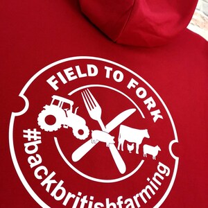 May include: Red hooded sweatshirt with a white circle logo that says "Field to Fork #backbritishfarming" with a tractor, fork, knife, pig, cow, chicken, and sheep inside the circle.