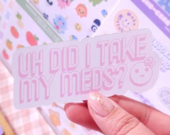 Può includere: Un adesivo rosa con il testo "Uh did I take my meds?" in bianco con un contorno rosa. L'adesivo ha un viso da cartone animato con un naso rosa e un occhio bianco.