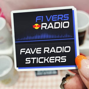 Puede incluir: Adhesivo cuadrado con el texto "F1 VERS RADIO" y "FAVE RADIO STICKERS" en blanco sobre fondo negro. El adhesivo tiene un borde azul y blanco y un logotipo de Red Bull. Lo sostiene una mano con manicura naranja y blanca.