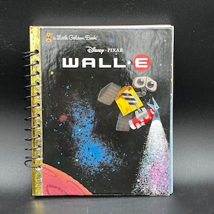 May include: A spiral-bound notebook featuring the Disney Pixar movie "WALL-E." The cover displays WALL-E in space with the title in large white letters. The notebook is a "Little Golden Book" with gold-colored edges and a black spiral binding.