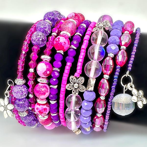 Pulsera de cuentas rosa fuerte y morada hecha a mano con dijes de cristal