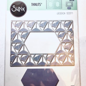 May include: A silver metal die-cutting template with a geometric design. The template is packaged in a clear plastic bag with a white label that reads "Sizzix Thinlits® Jessica Scott 664398".