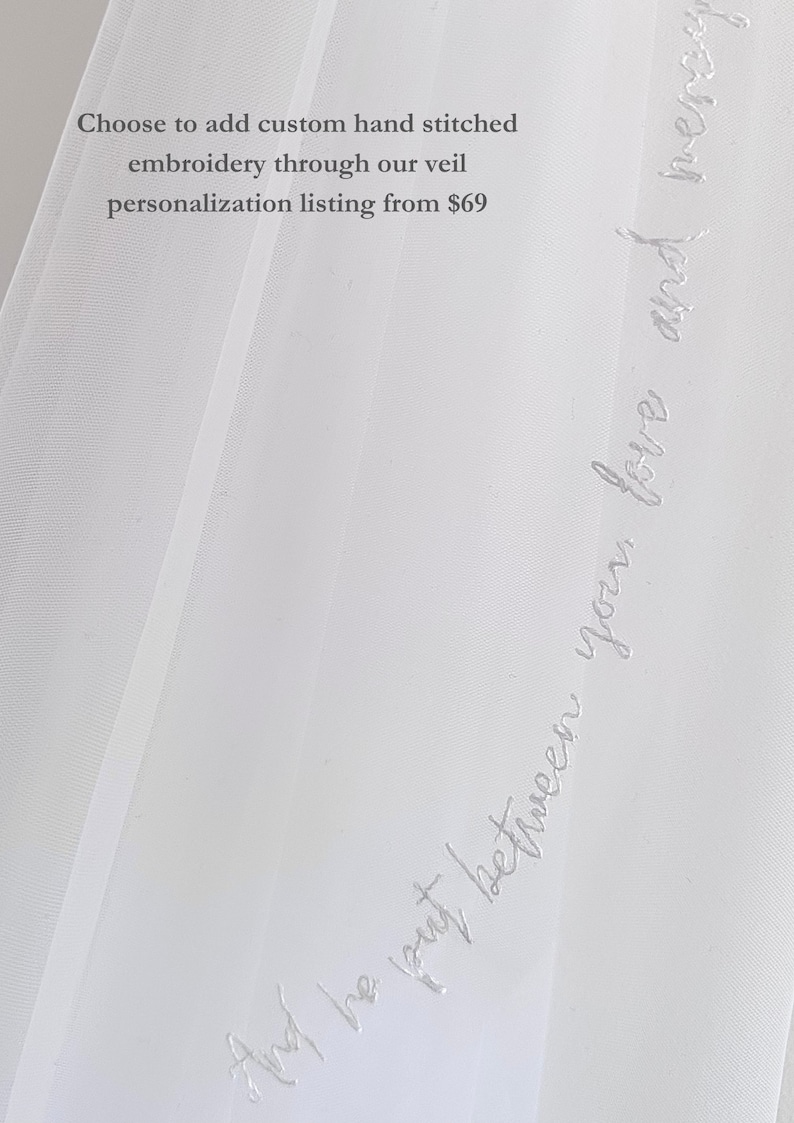 K&ouml;nnte beinhalten: Ein transparenter wei&szlig;er Brautschleier mit zarter wei&szlig;er Schreibschrift-Stickerei entlang der Kante. Der Stoff ist durchscheinend und leicht. Der Text lautet: Choose to add custom hand stitched embroidery through our veil personalization listing from $69 und And he put between you, love and mercy.