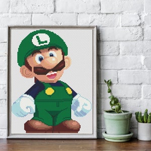 May include: A green and brown pixel art illustration of a video game character with a green hat and a mustache. The character is smiling and has a large 'L' on the front of their hat.