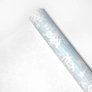 May include: A roll of blue wrapping paper with a white snowflake pattern.