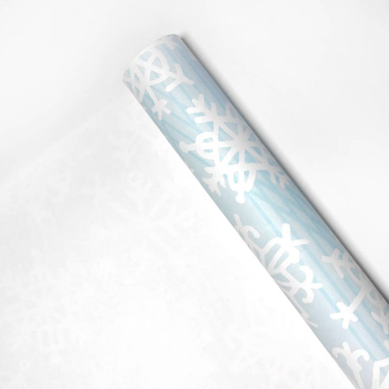 May include: A roll of blue wrapping paper with a white snowflake pattern.
