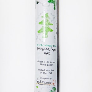May include: A roll of green and white Christmas wrapping paper with a green stylized Christmas tree design. The paper is 6 feet by 30 inches and is printed with love in the USA. The label also says "O Christmas Tree Wrapping Paper Roll" and "Designed by Studio'SCHMIDT".