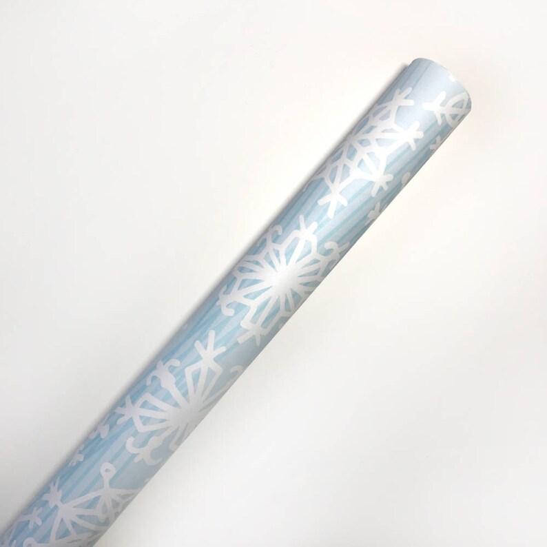 May include: A roll of blue wrapping paper with a white snowflake pattern.