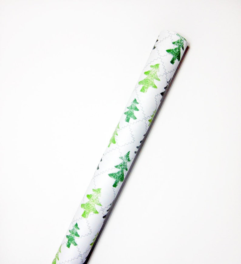May include: A roll of white wrapping paper with a repeating pattern of green Christmas trees.