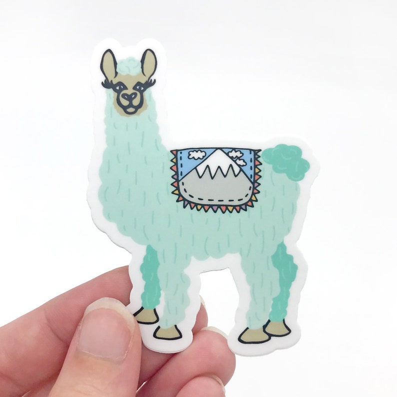 Puede incluir: Una pegatina de llama azul claro con un dise&ntilde;o de monta&ntilde;a en la espalda. La llama tiene la nariz marr&oacute;n y pesta&ntilde;as negras.