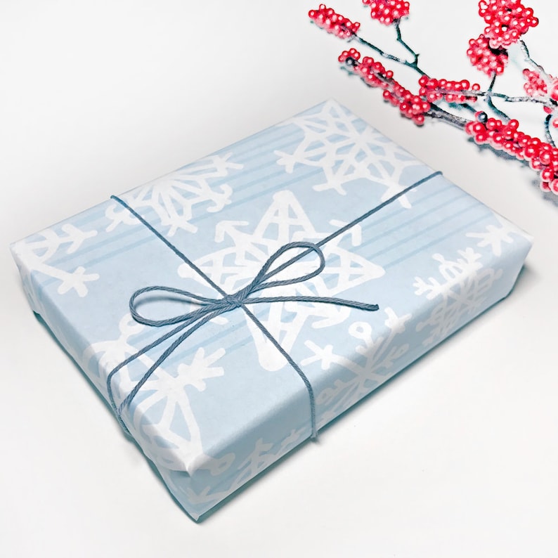 May include: A light blue gift box with a white snowflake pattern and a gray ribbon tied in a bow.