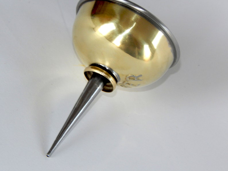 K&ouml;nnte beinhalten: Eine &Ouml;ldose aus Messing mit einem silbernen Auslauf und einem silbernen Rand. Die Dose hat einen kleinen Ring um die Oberseite und das Wort "York" ist auf der Seite eingraviert.