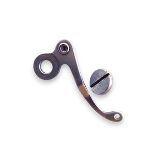 May include: A silver-colored metal component with a curved design, featuring a circular opening and a small hole at the end. A separate, round, silver-colored screw is also present.