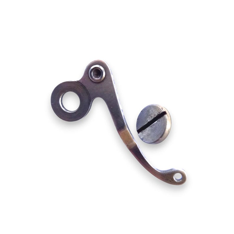 May include: A silver-colored metal component with a curved design, featuring a circular opening and a small hole at the end. A separate, round, silver-colored screw is also present.