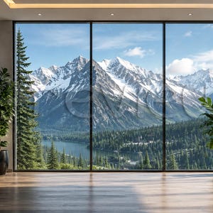 May include: A large window frames a scenic mountain view with snow-capped peaks, a lake, and a forest. The interior features a hardwood floor, potted plants, and a framed landscape artwork. The room is filled with natural light.
