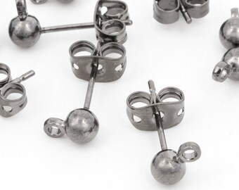 May include: Close-up of several small, dark gray ball stud earrings with matching earring backs. The earrings have a simple, minimalist design, with a small ball at the front and a post for insertion. The earring backs are butterfly style.