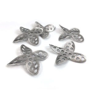May include: Four silver metal butterfly charms with a cutout design and a distressed finish.
