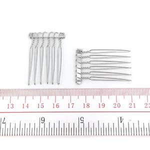 May include: Two silver hair combs with a twisted wire design. The combs are approximately 1.5 inches long and have seven teeth each.
