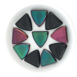 May include: A collection of iridescent triangle-shaped tiles in black, green, and purple.