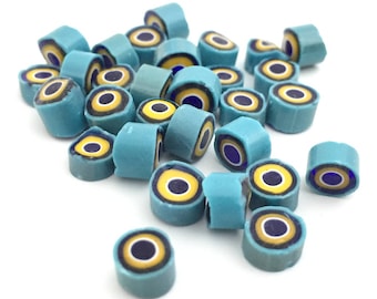 Könnte beinhalten: Ein Haufen blauer und gelber Zuckerperlen mit schwarzem Kern. Die Perlen sind zylinderförmig und haben ein Ringmuster.