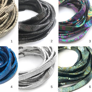 Puede incluir: Seis hebras de cuentas de hematites en forma de chevron en varios colores, incluyendo plata, negro, iridiscente, azul, blanco y verde.