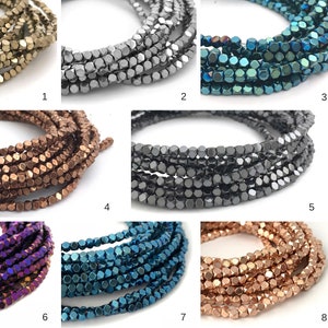 May include: Eight strands of faceted, metallic beads in various colors, including gold, silver, blue, copper, and purple. The beads are arranged in rows, with each row showing a different color.