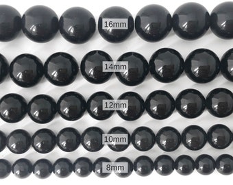 Puede incluir: Cuentas redondas negras de varios tamaños, que van de 8 mm a 16 mm. Las cuentas están dispuestas en filas, con las cuentas más grandes en la parte superior y las más pequeñas en la parte inferior.