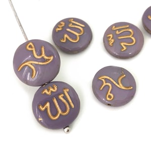 May include: Round, lavender-colored beads with gold-colored Arabic calligraphy. The beads are strung on a thin, silver-colored wire. The calligraphy appears to be religious in nature. The beads are on a white background.