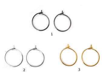 May include: Three pairs of hoop earrings in different metallic finishes: dark gray, silver, and gold. Each pair features a simple, circular design with a looped closure. The earrings are displayed against a plain white background.