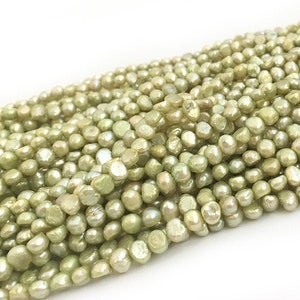 Może przedstawiać: Sznur jasnozielonych pereł słodkowodnych. Perły są nieregularne i mają lekko tęczowy połysk.