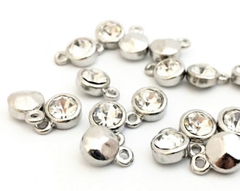 May include: A group of silver-toned metal charms with clear crystal rhinestones. Each charm has a loop for attaching to a bracelet or necklace.