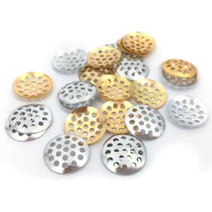 Könnte beinhalten: Ein Haufen kleiner, runder, metallener Maschenplatten in Gold- und Silberfarben. Die Platten haben ein dekoratives, gemustertes Design.