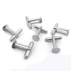 May include: Six silver cufflinks with a round, flat back and a small, round, raised button on the front.