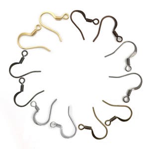 May include: Assortment of earring hooks in gold, silver, and bronze. The hooks are arranged in a circle on a white background.