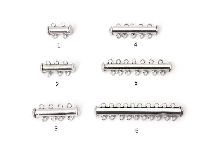 May include: Six silver magnetic clasps for jewelry making. The clasps have different lengths and numbers of loops. The clasps are numbered 1 through 6.
