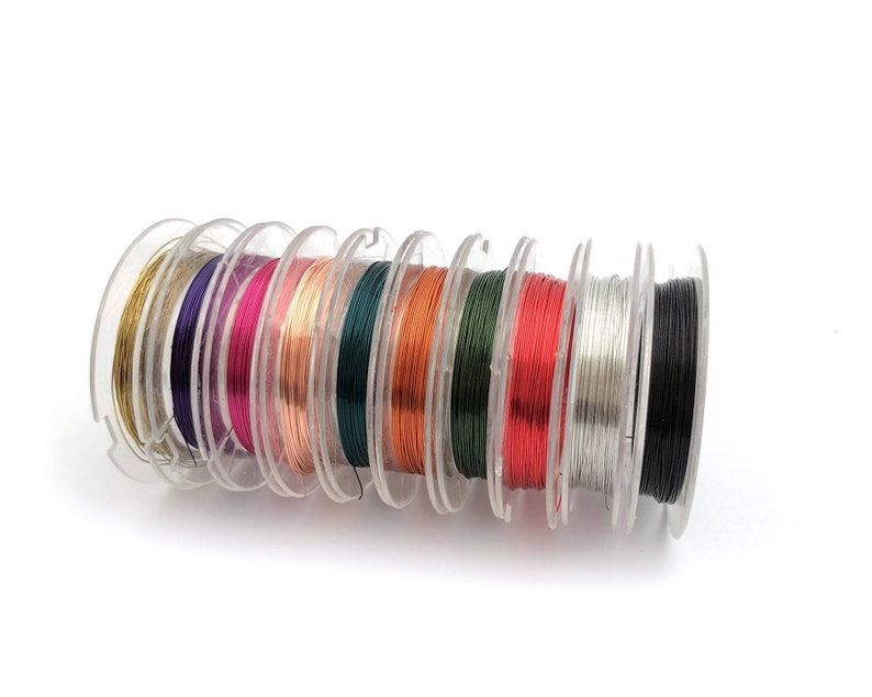 May include: A set of spools of colorful wire, including gold, purple, pink, copper, green, orange, red, silver, and black.