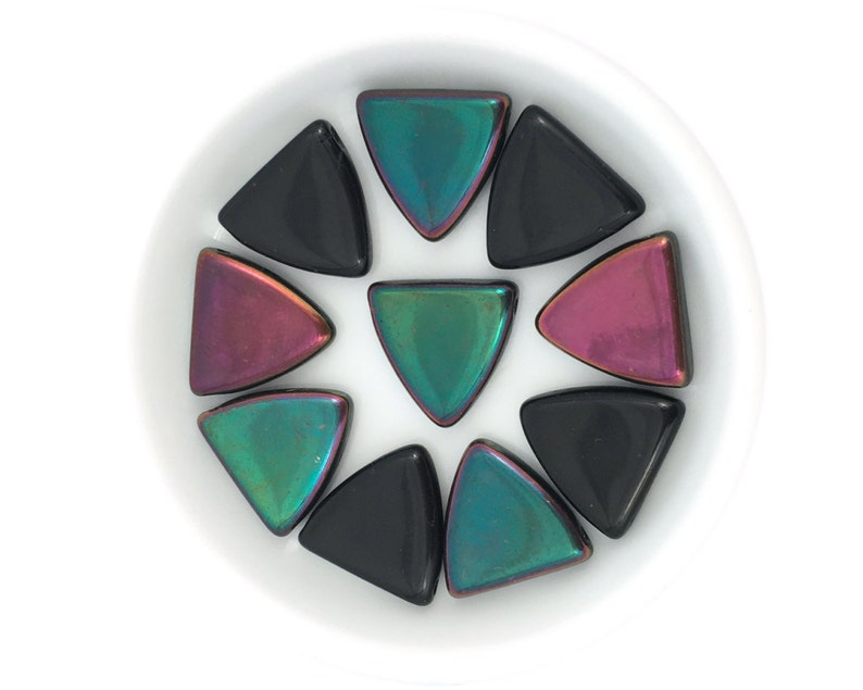 May include: A collection of iridescent triangle-shaped tiles in black, green, and purple.