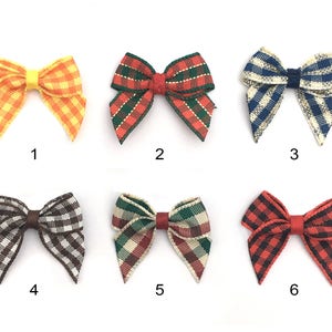 May include: Six different plaid ribbon bows in various colors, including red, green, blue, yellow, and brown. The bows are arranged in two rows of three, with each bow numbered 1 through 6.