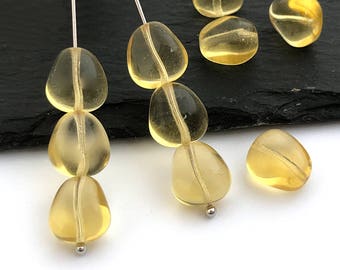 May include: A strand of yellow gemstone beads, strung on a silver wire. The beads are faceted and have a translucent appearance.