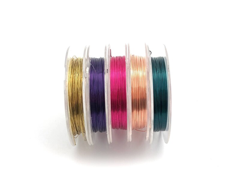 May include: Five spools of colorful wire for jewelry making. The spools are arranged in a row, with the colors from left to right: gold, purple, pink, copper, and green.