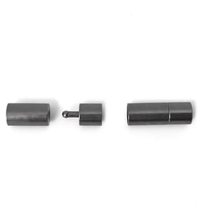 May include: A set of three black metal magnetic clasps for jewelry making. The clasps are cylindrical and have a smooth finish.