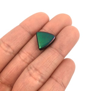 May include: A triangular iridescent green gemstone with a black edge.