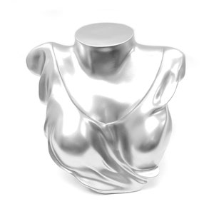 Op de afbeelding: Zilverkleurig buste-mannequin met een gedrapeerd stoffen ontwerp, ideaal voor het presenteren van kettingen of andere sieraden.