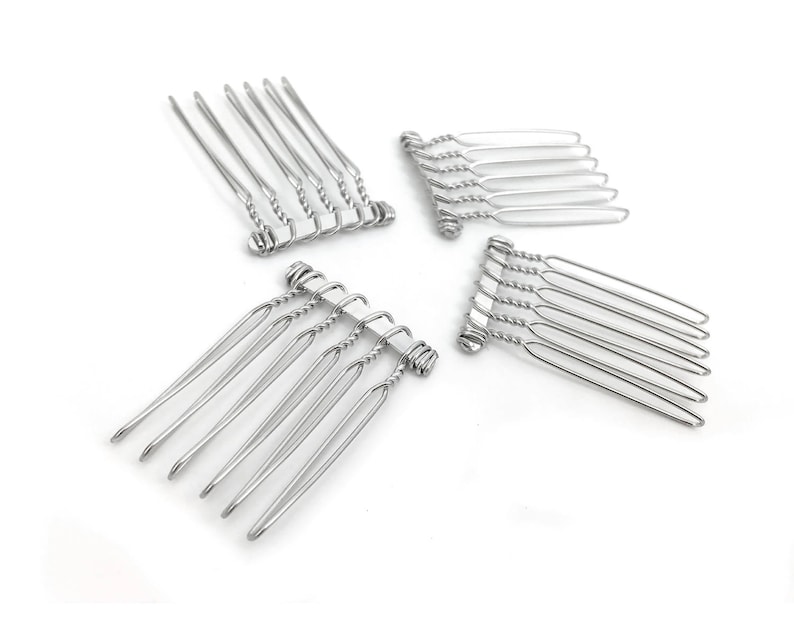 May include: Four silver hair combs with a twisted wire design. Each comb has seven teeth.