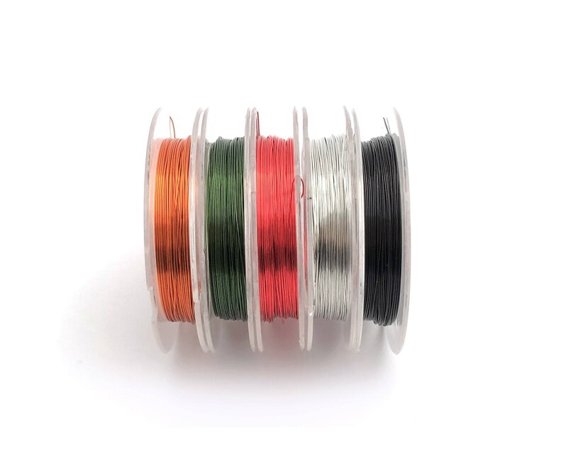 May include: Six spools of wire in different colors: orange, green, red, silver, and black. The spools are arranged in a row.