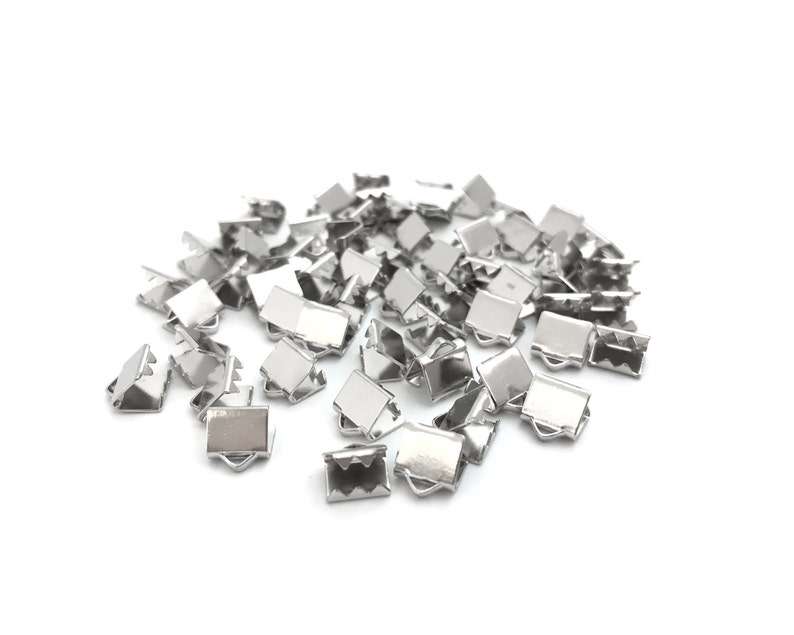 Op de afbeelding: Een stapel zilveren metalen sluitingen, ook wel bekend als kreeftsluitingen, die worden gebruikt voor het maken van sieraden.