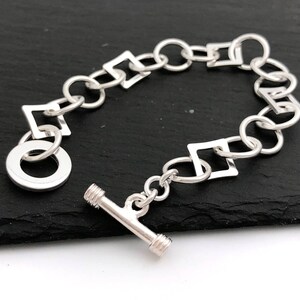 Pu&ograve; includere: Un braccialetto d'argento con chiusura a scorrimento e maglie quadrate. Il braccialetto &egrave; in argento sterling e misura circa 18 cm di lunghezza.