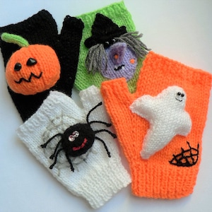 May include: Five knitted fingerless gloves with Halloween-themed appliques. The gloves are in black, white, orange, green, and purple. The appliques include a pumpkin, a spider, a ghost, a witch, and a spider web.