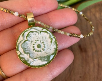 Halskette mit grünem Mohn. Glaspaste, 2,5 cm Durchmesser. Kettenlänge: 40 cm. Peridot-Edelsteine. Originaldesign von S. Dunoyer.